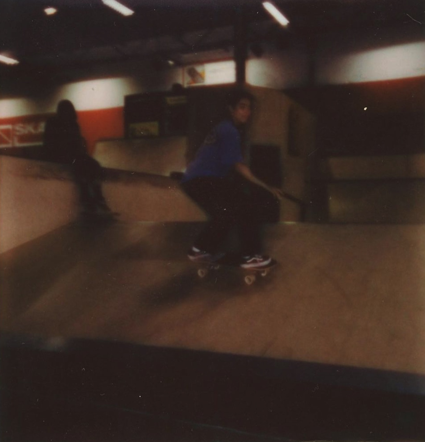 Kind met bescherming aan en helm op houd skateboard vast